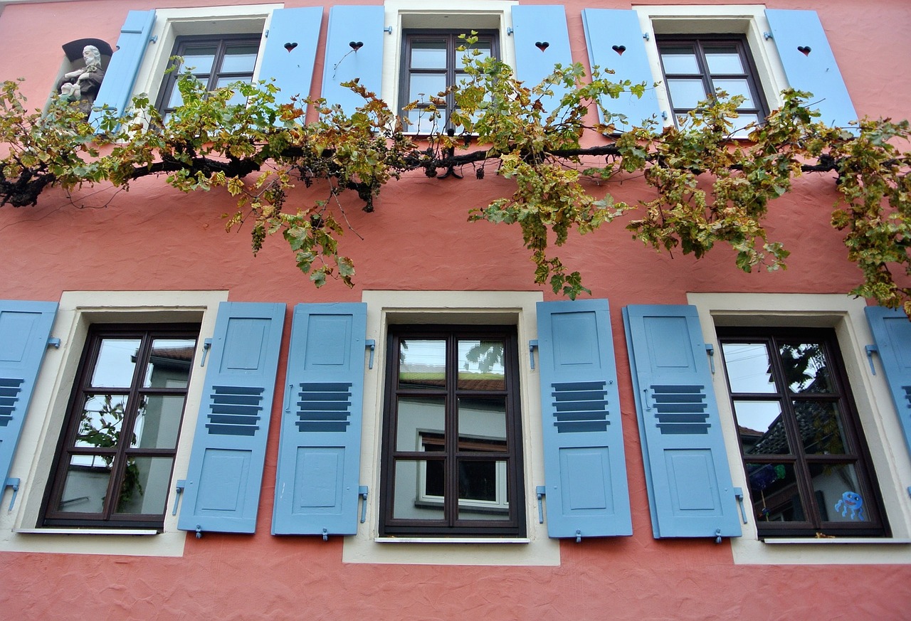 Pinkes Haus mit blauen Fensterläden